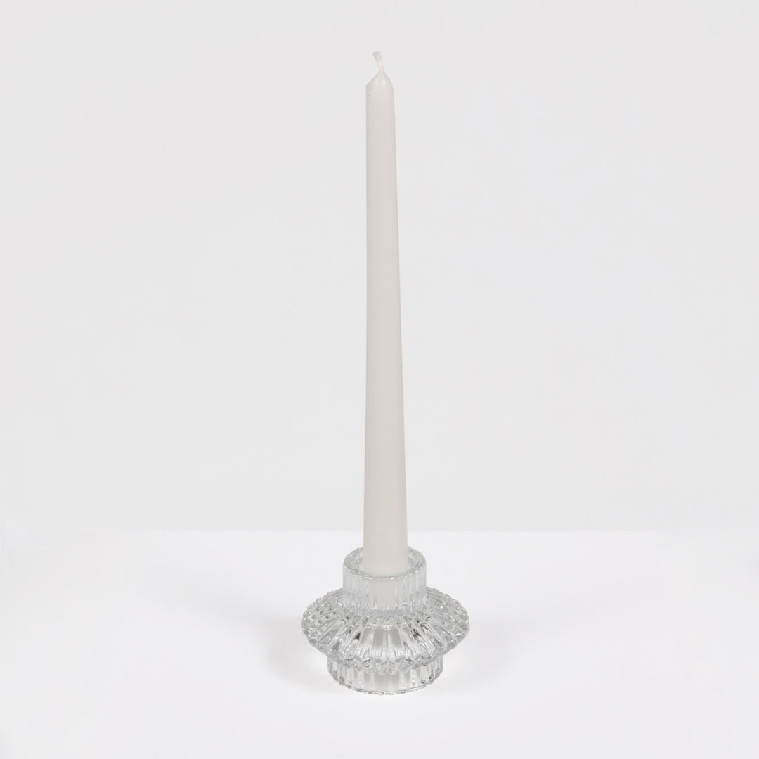 Decorative candle holder with a white candle on a light grey background