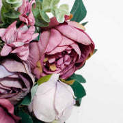 close up photo of mauve coloured rose and closed lavender coloured rose in bouquet