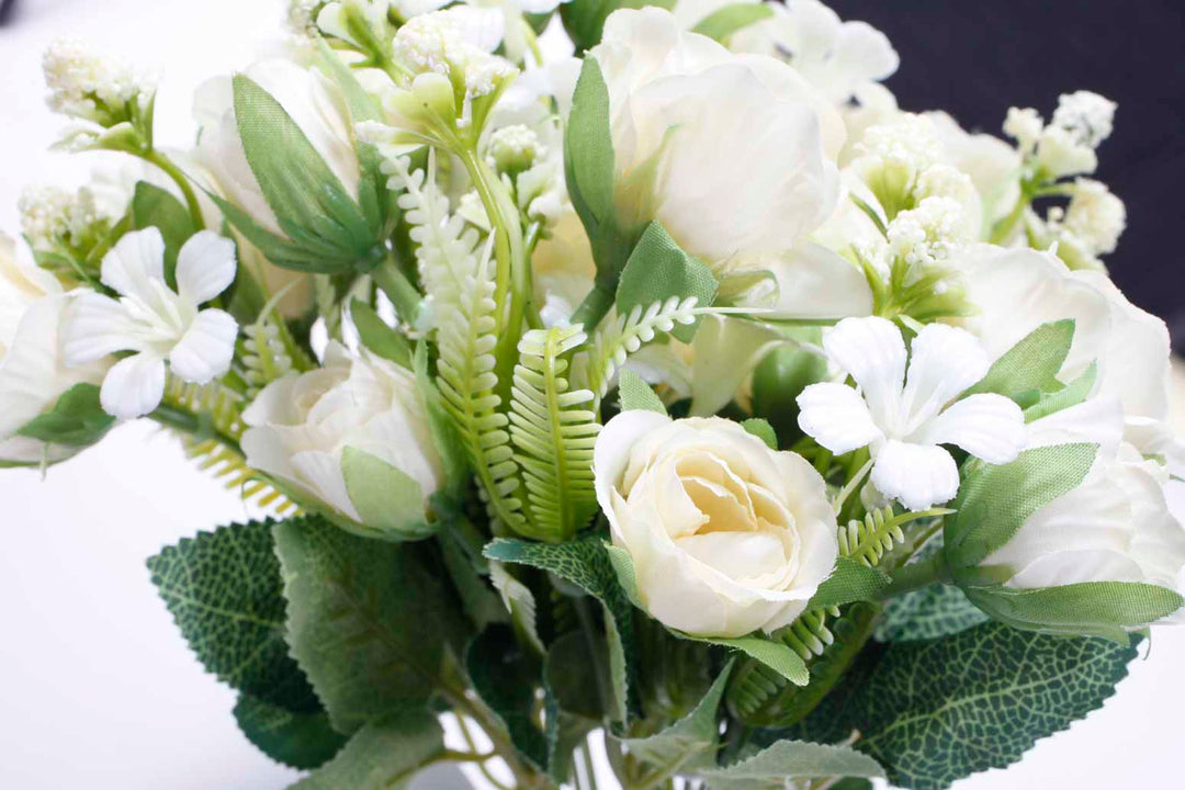artificial rose flower bouquet close up cream flowers and green leaves