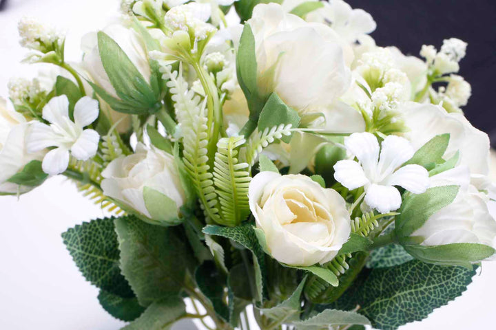artificial rose flower bouquet close up cream flowers and green leaves