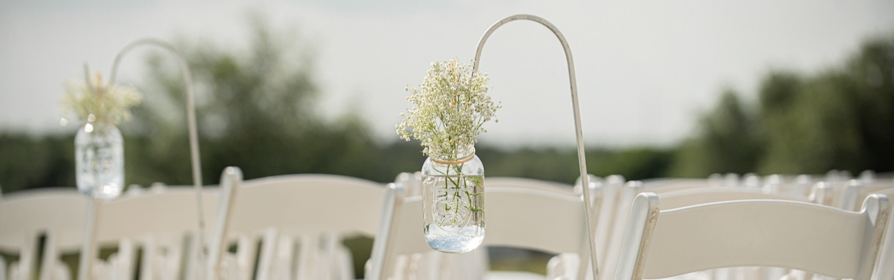 White Peg Based Shepherd Hook in Grass wedding ceremony with White lantern hanging from ribbon