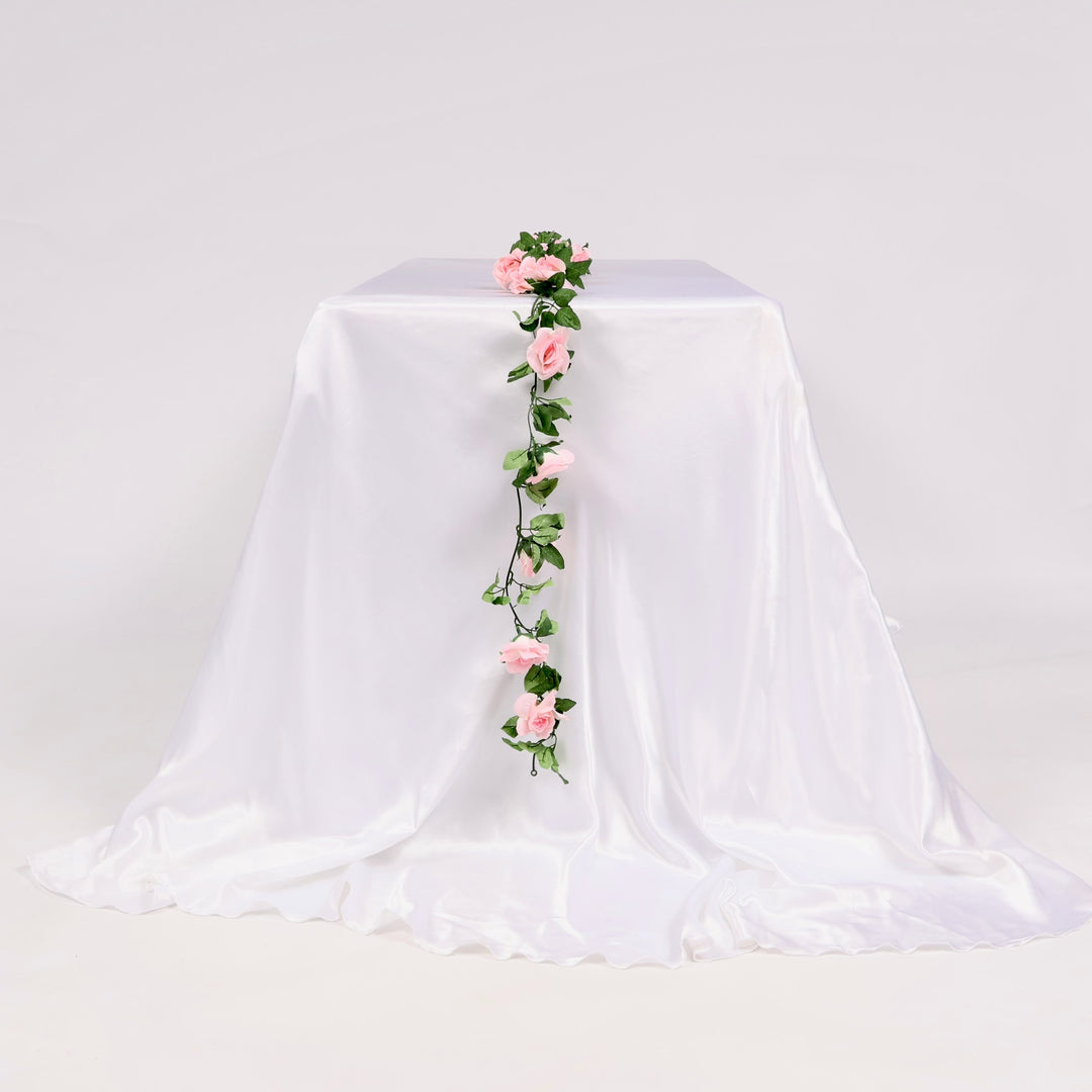 White tablecloth with pink floral garland on a white background