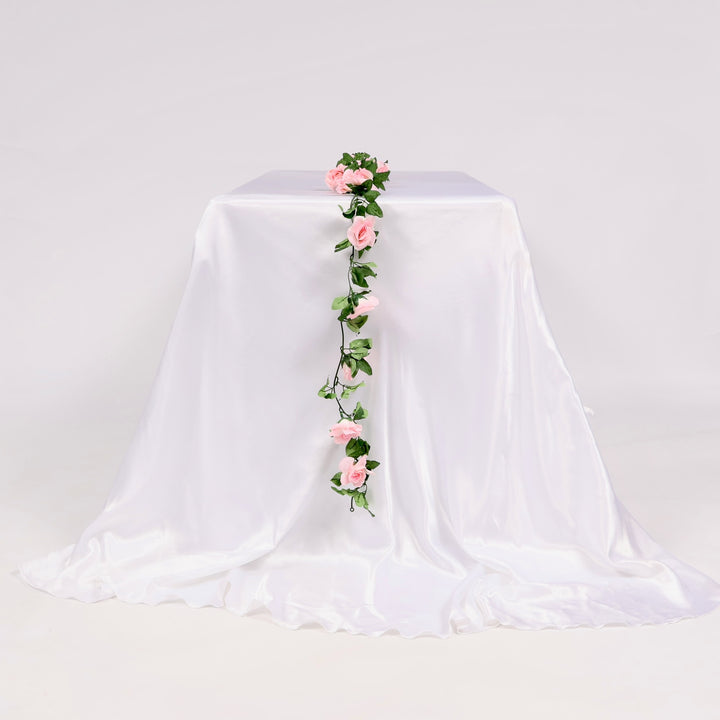White tablecloth with pink floral garland on a white background