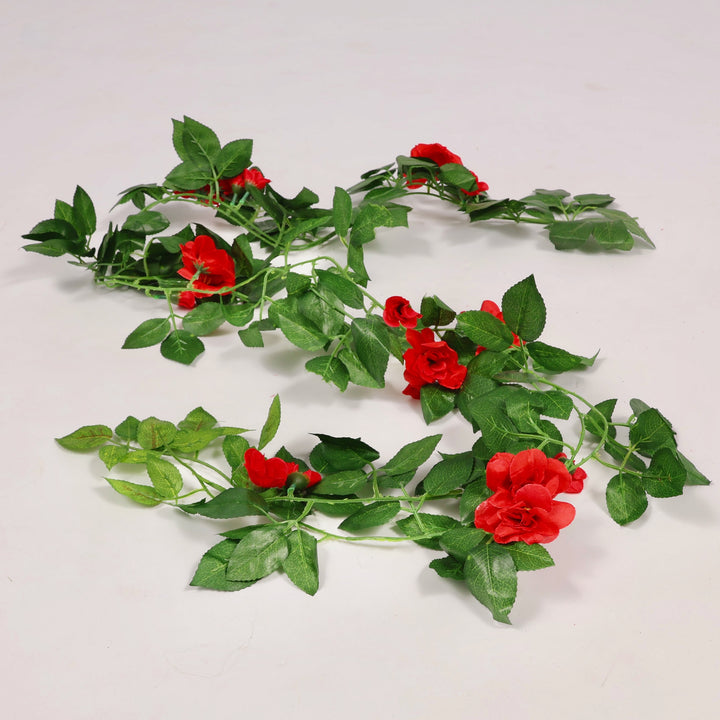 Artificial green vine with red flowers on a white background