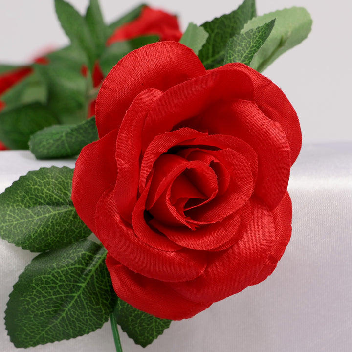 Close-up of a red rose with green leaves on a white background