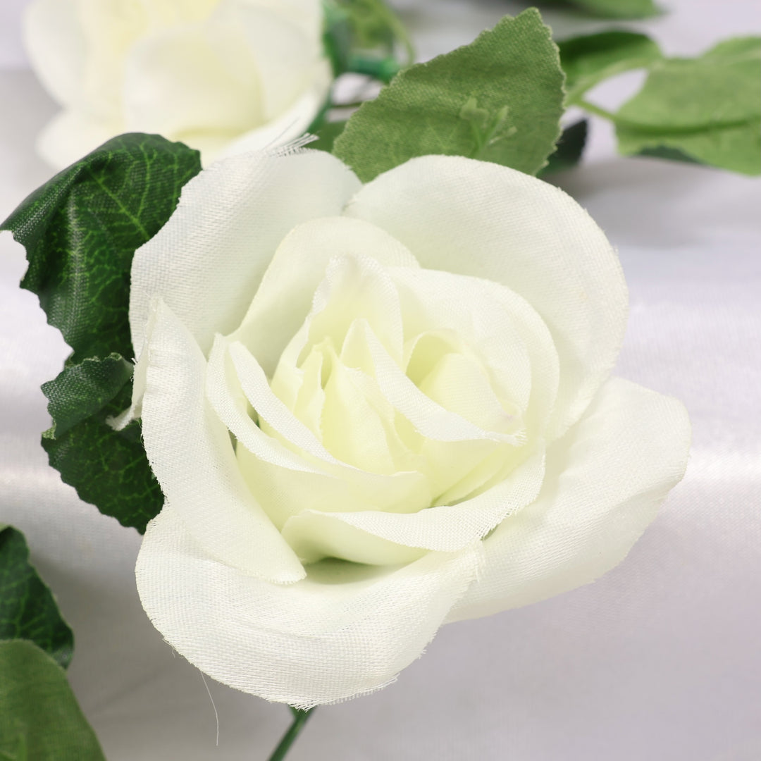 Close-up of a white rose with green leaves on a light background
