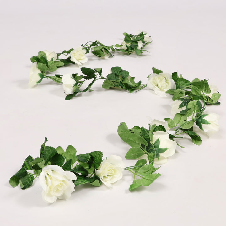 Artificial flower garland with white flowers and green leaves on a white background