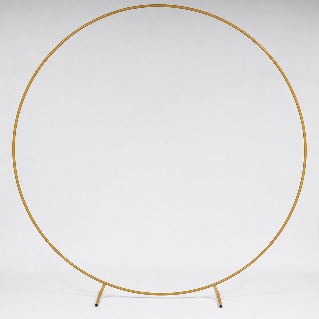 A gold metal circular stand photographed against a seamless white studio background.