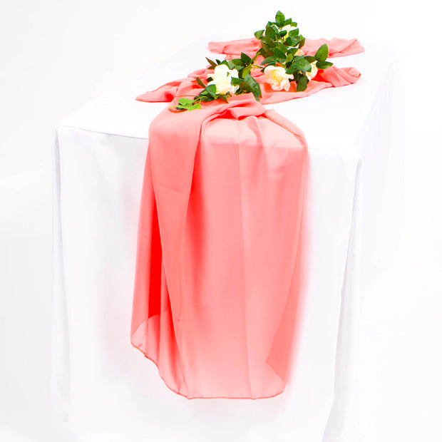 Coral chiffon runner on a white tablecloth with flower vine