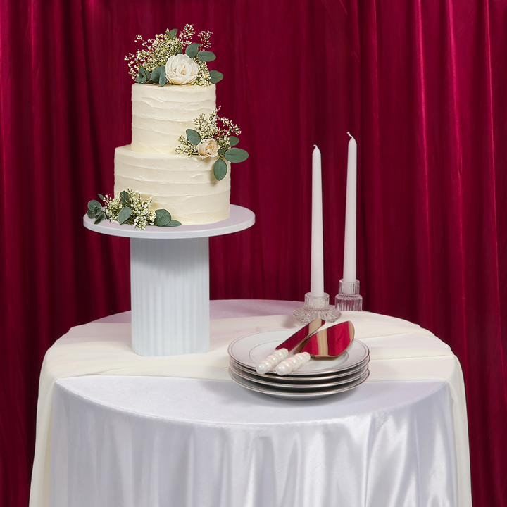 Cake Stand - Ribbed - White (25x20.5cm), on cocktail bar table with taper candles, plates and bubble handle cake knife set, burgundy backdrop and white satin tablecloth