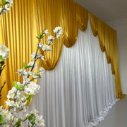 White ice silk backdrop curtain with Gold ice silk contour swag behind white flowers