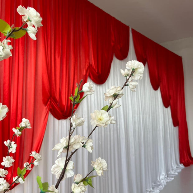 Ice Silk Satin Draping Backdrops - 6 meters length x 3 meters high - Red behind white flowersIce Silk Event Backdrop with Venetian Contour Stage Curtain / Valance Swag (Red and White) 3m wide x 3m high side angle close