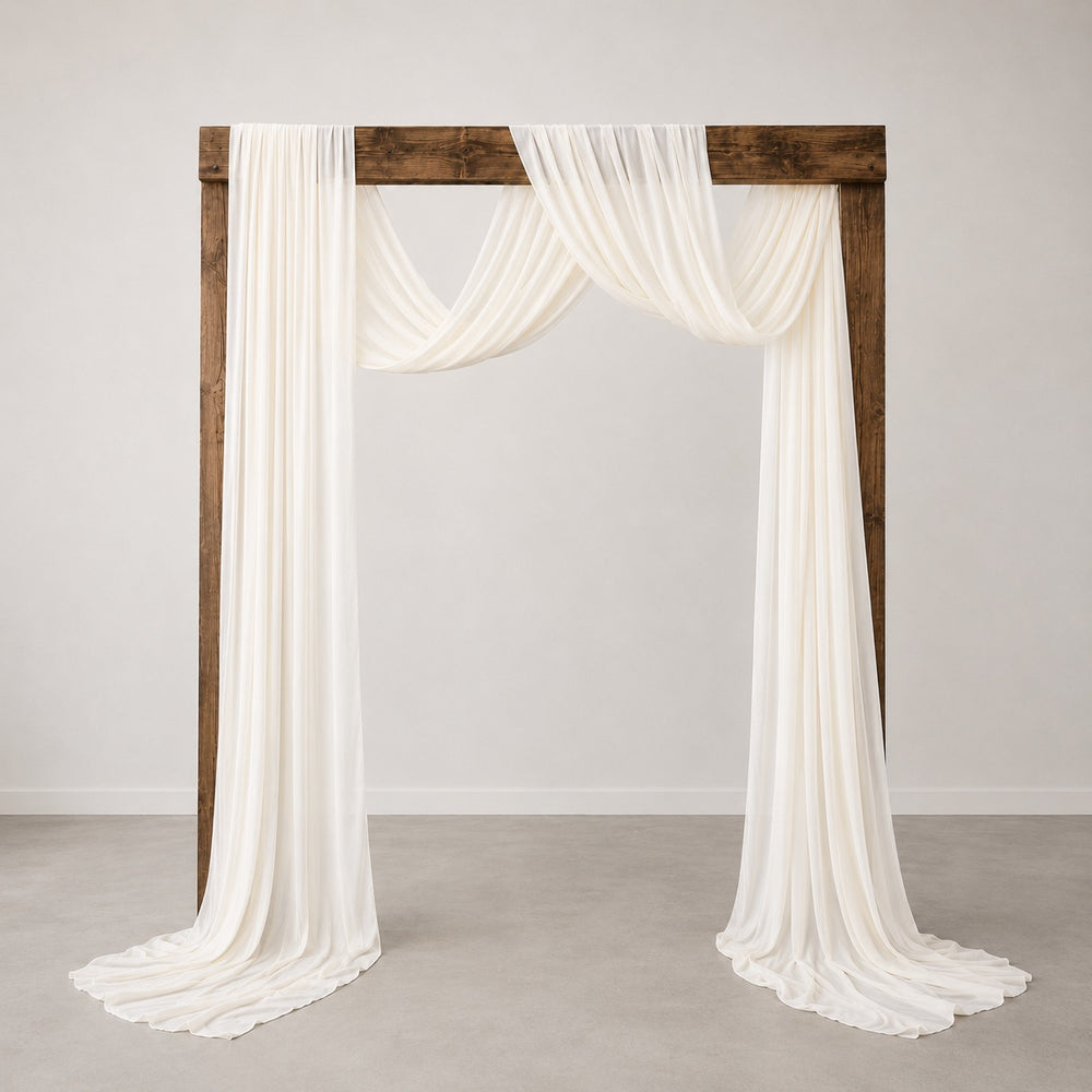 An Ivory chiffon draped fabric with a rustic dark brown wooden arch frame