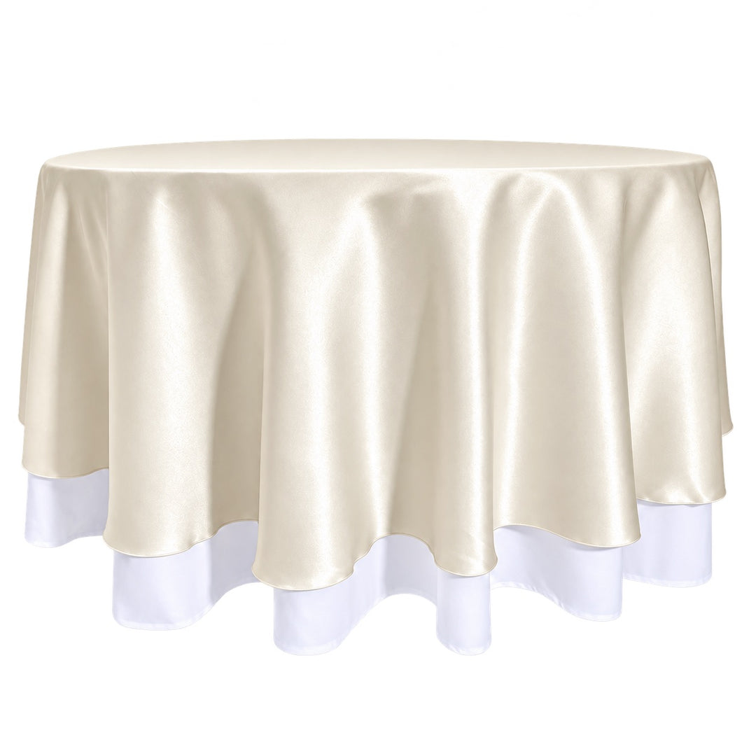 A round tablecloth in ivory satin, draped over a round table with a white underlay, visible at the bottom edge.