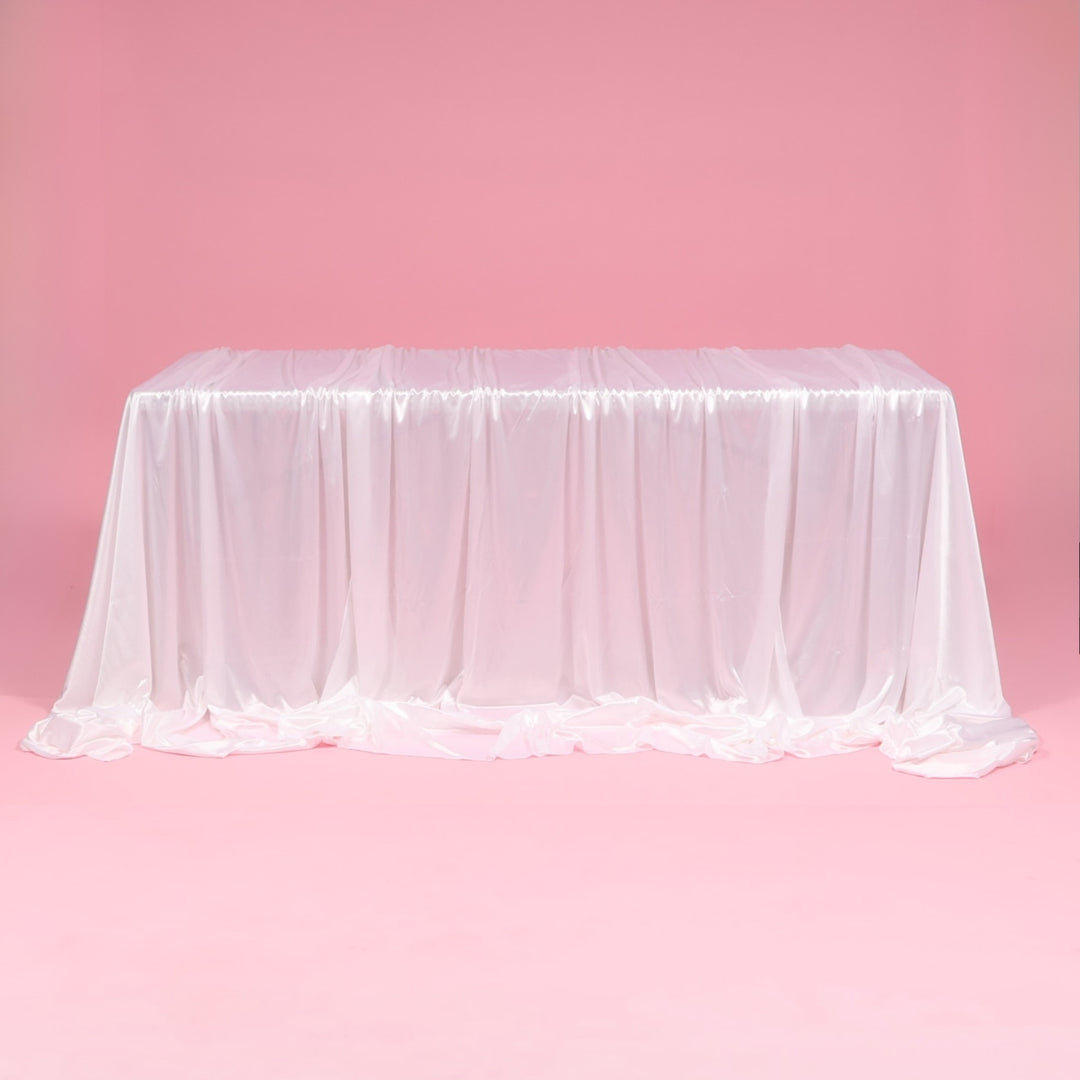 White tablecloth on a pink table against a pink background