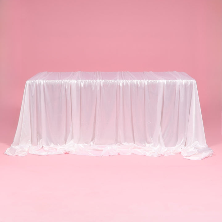 White tablecloth on a pink table against a pink background