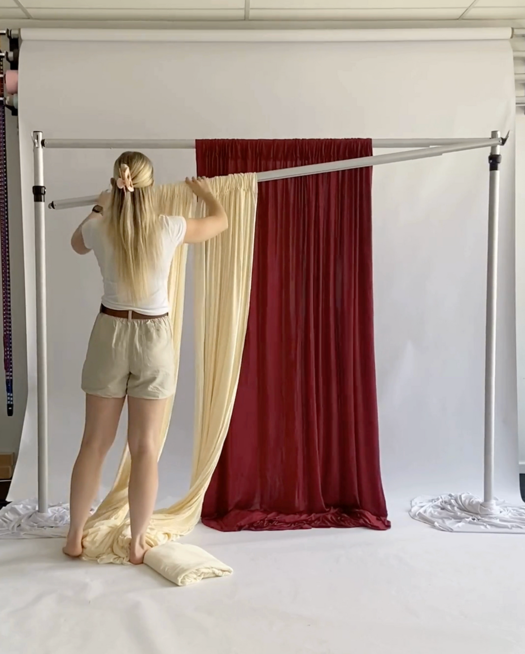 Ivory backdrop panels with Wine Red panel set up on second crossbar behind creating a layered backdrop effect