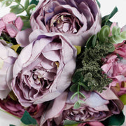close up of lavender coloured rose and green foliage