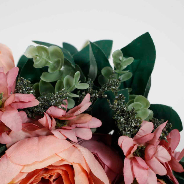 Close up of green foliage, including leaf and baby tears with pink daisies on peach Maroon Rose Flower Bouquet