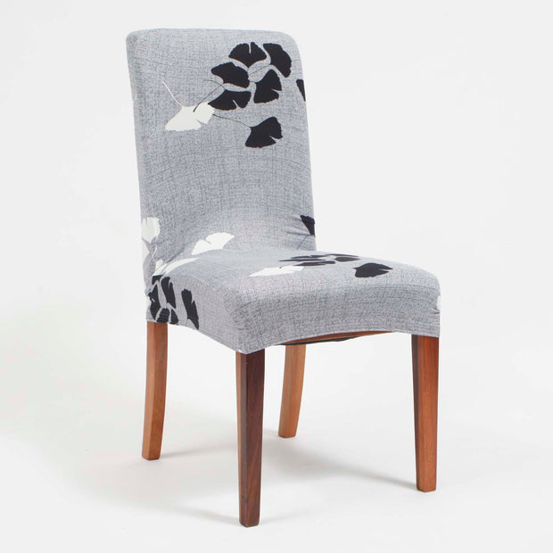 Grey lycra chair topper with black & white leaf design on chair with wooden legs
