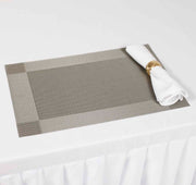 Silver Woven PVC Placemat with White Cloth Napkin and Gold Napkin Ring