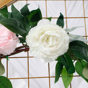close up of large white rose flower with green leaves on garland on mesh frame